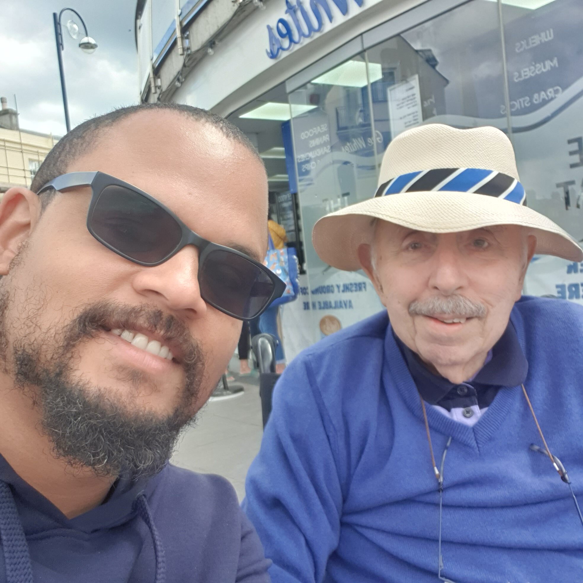 A male live in carer and a client at a fish bar having a good time smiling