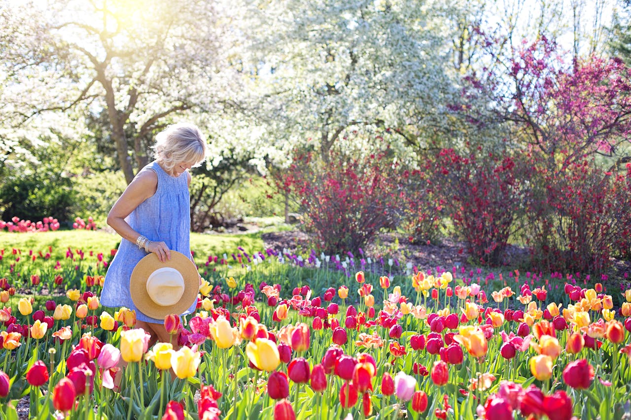 A woman walking in a field of flowers.