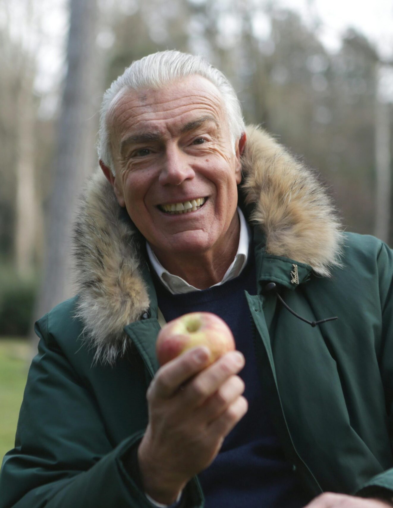 An elderly man with an apple.