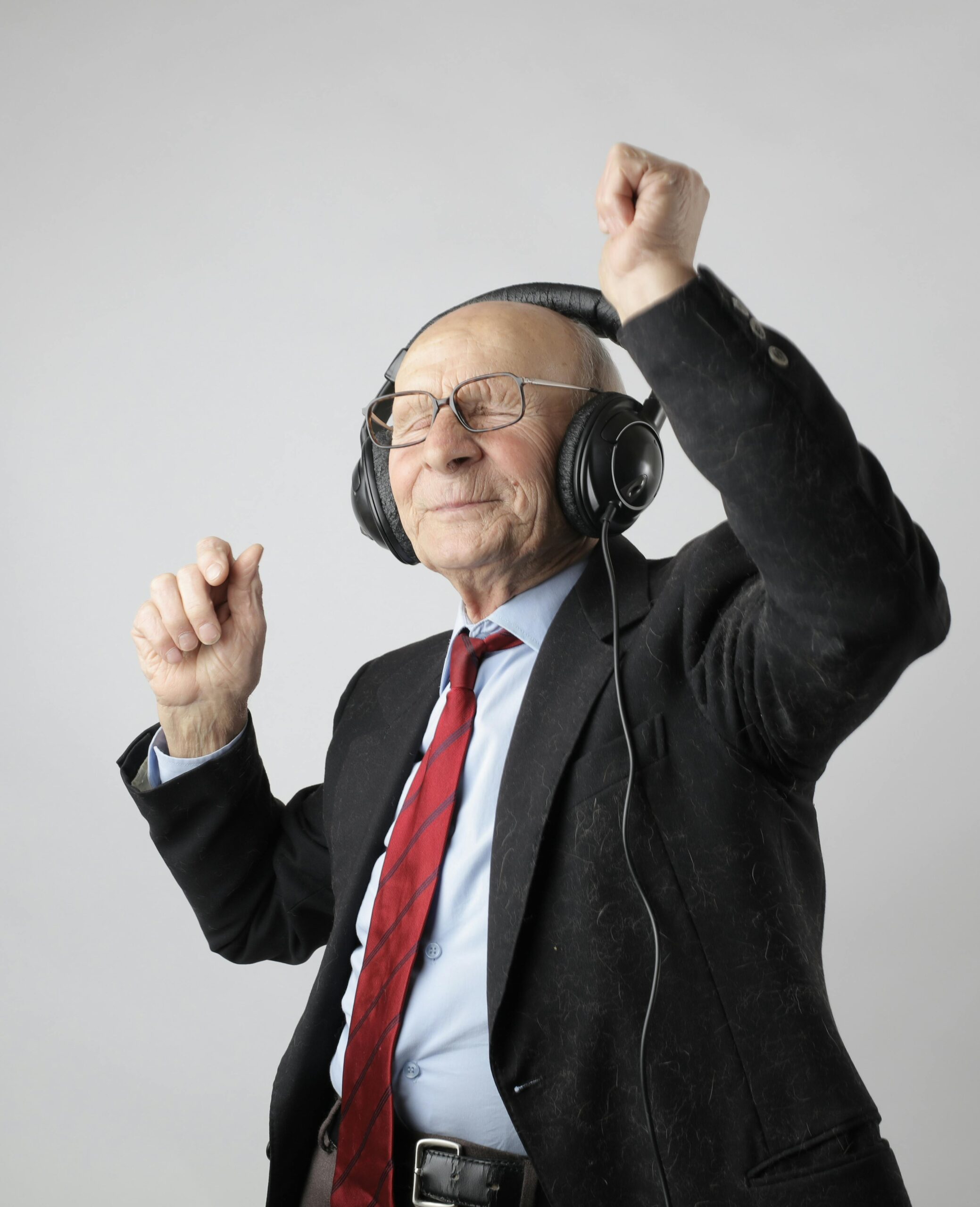 elderly man having a great time dancing to music on his headphones